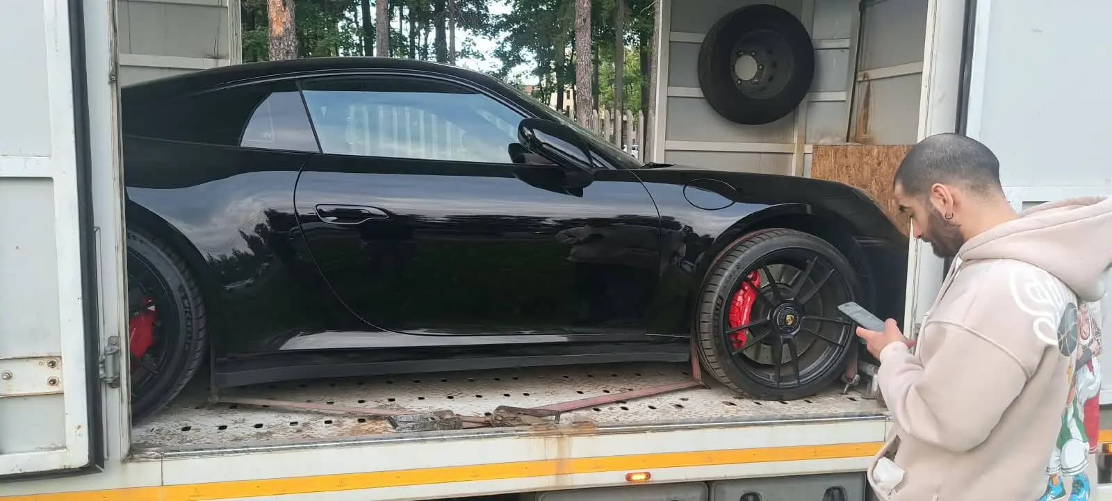 Porsche 911 закреплён ремнями за колёса в одноместном закрытом автовозе