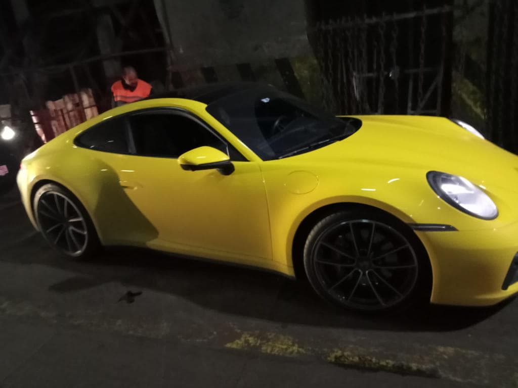 Жёлтый спорткар Porsche 911 перед погрузкой в крытый автовоз