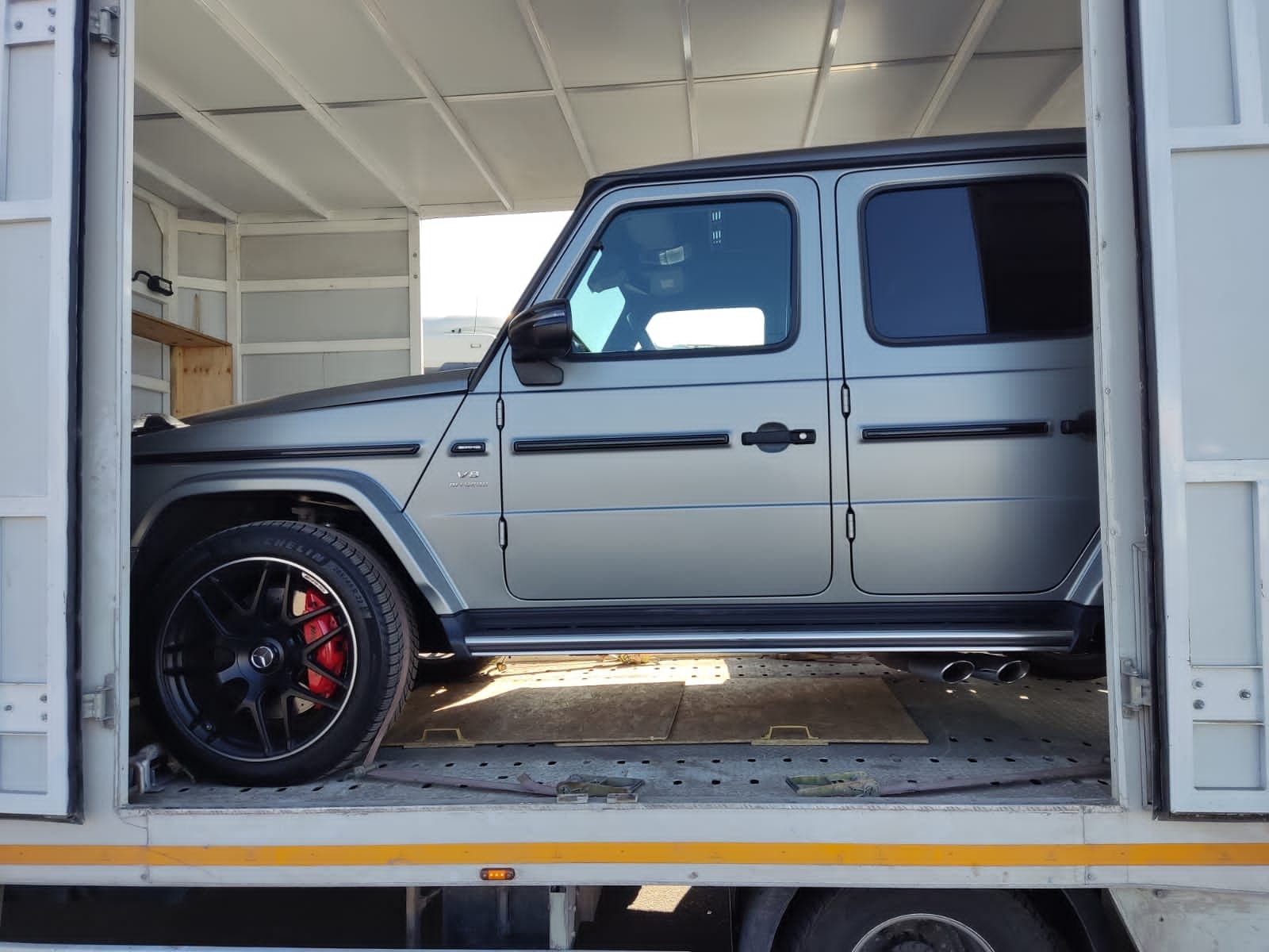 Mercedes-AMG G63 внутри крытого автовоза с открытыми дверями